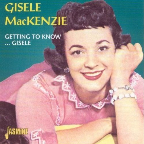 "Album cover featuring a smiling woman in a pink dress against a teal background."