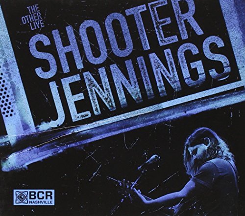 "Shooter Jennings album cover featuring a man playing drums on a dark stage."