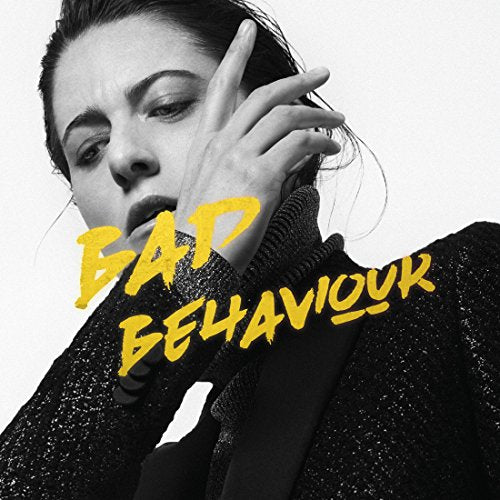 Black and white portrait of Kat Frankie with yellow text "BAD BEHAVIOUR".