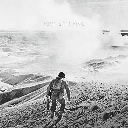 Black and white album cover featuring a soldier walking through a desolate landscape.
