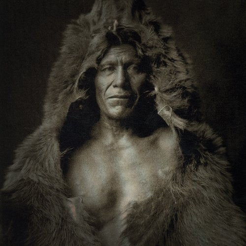Sepia-toned portrait of a man with a fur hood and serious expression.