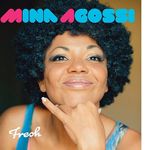 "Album cover featuring a smiling woman with afro hairstyle and blue top."