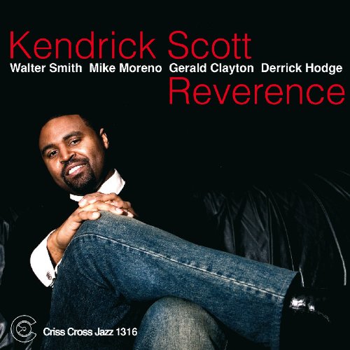 Kendrick Scott album cover featuring a man sitting with his leg crossed, against a black background.