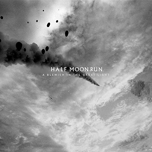 "Black and white album cover with cloudy sky, smoke, and falling objects."