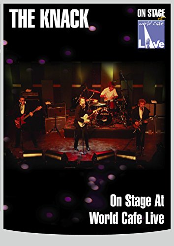 The Knack band performing on a dark stage with stage lights.