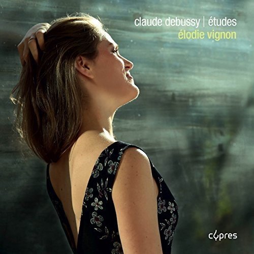 CD cover with a woman in a black dress, gazing right, blurred background.