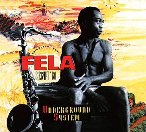 Fela Kuti sitting with a saxophone against a yellow and orange painted background.