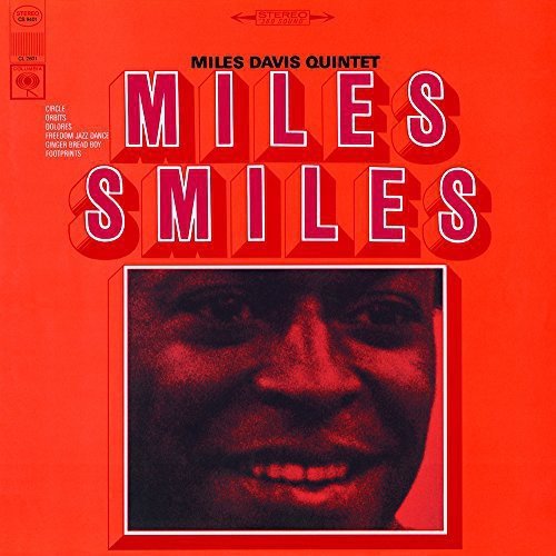 Red album cover with a close-up of Miles Davis' smiling face.