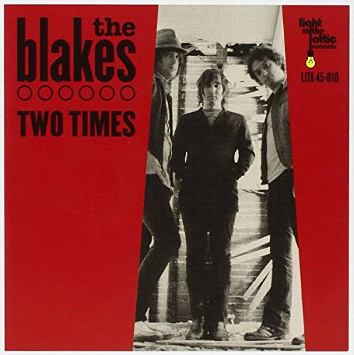Red vinyl record cover with black text and a black-and-white photo of three men.