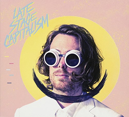 Album cover with man in white suit and exaggerated mustache and sunglasses on pink background.