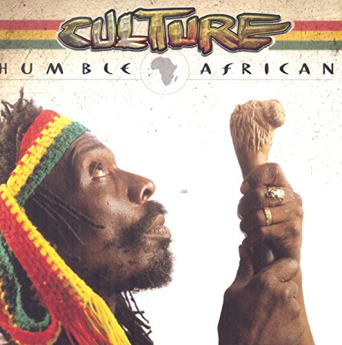 Album cover with a man holding a lion figurine, wearing a colorful knit hat.