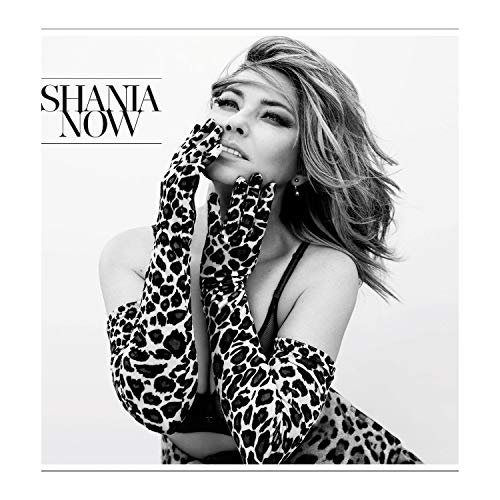 Black and white portrait of Shania Twain in leopard print gloves.
