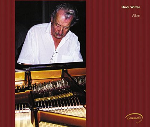 "Album cover with a man playing piano on a red background."
