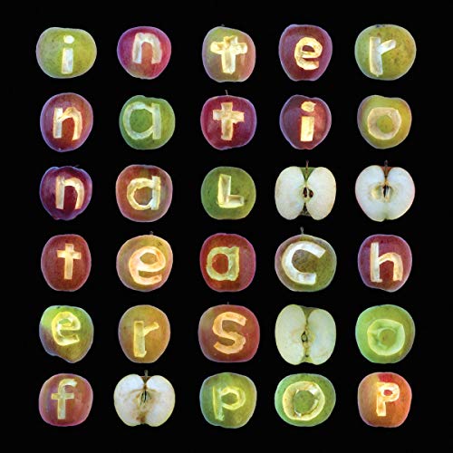 "Album cover with apples cut open, spelling 'International Teachers of Pop' on a black background."