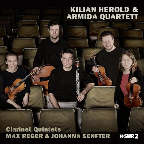 Armida Quartett and clarinetist posing in a theater setting.