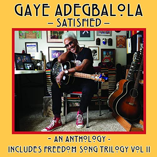 Gaye Adegbalola sits with guitars in a room filled with art.