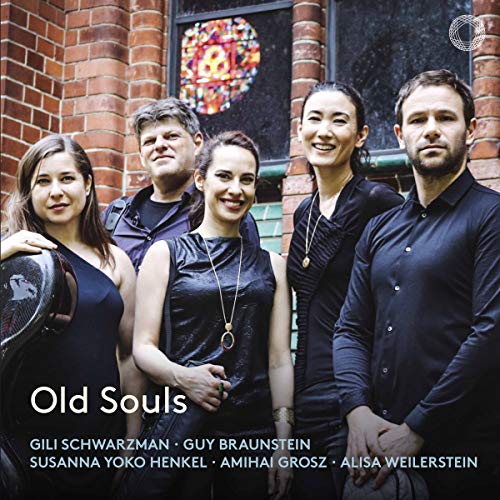 "Album cover featuring five musicians in dark attire standing before a brick wall."