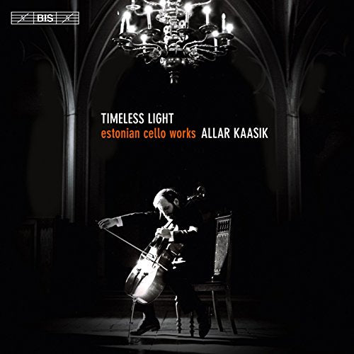 A cellist plays under a chandelier in a dimly lit, arched chamber.