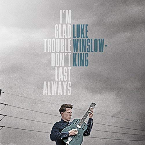 The alt text for the image is: "Man playing guitar against a cloudy sky with text overlay."