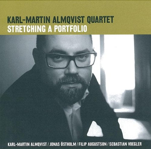Album cover featuring a man with glasses and a beard, olive green and black design.