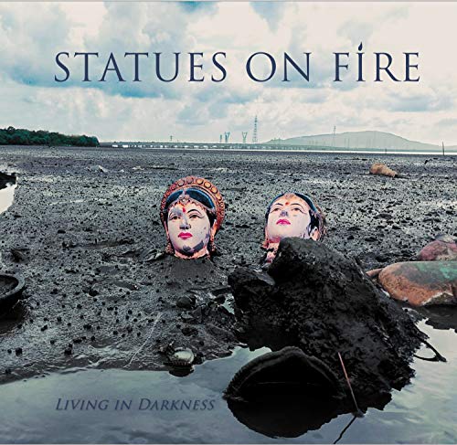 Album cover: Statues On Fire, “Living In Darkness”, with statue heads in mud.