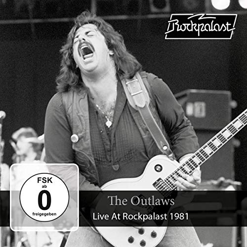 Black and white photo of a musician playing an electric guitar live.