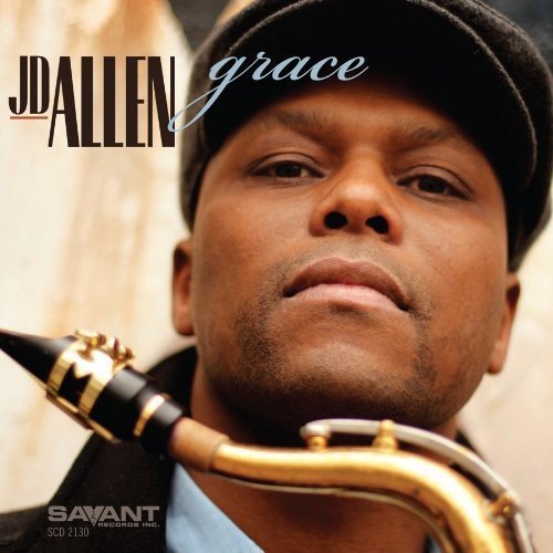 Man wearing a black cap holds a saxophone, close-up view.