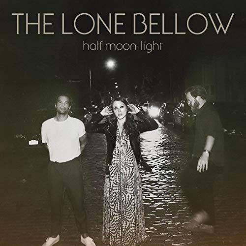 Vinyl album cover with three people standing on a wet street at night.