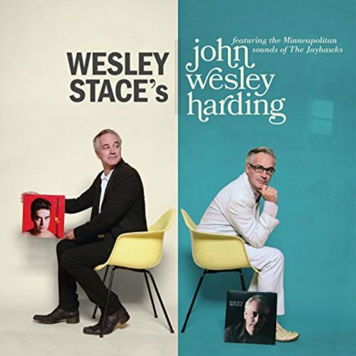 Man sits on yellow chair holding album cover, against split beige and teal background.