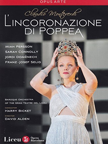 A woman in a silver dress adjusts a crown on her head.