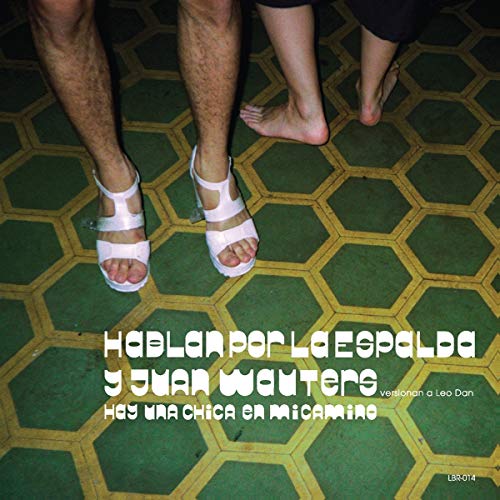 A vinyl record cover featuring a man and woman standing on a green hexagonal floor.