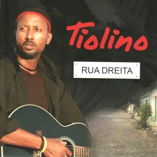 "Album cover featuring a man holding a guitar, with a street at night."