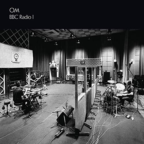 Black and white photo of a band recording in a professional studio.