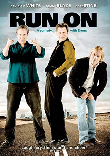"Three men standing on a road, looking directly at the camera."
