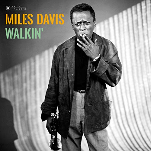 Black and white portrait of Miles Davis with trumpet, album cover.