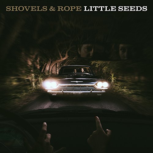 Album cover with a vintage car driving down a dark road at night.