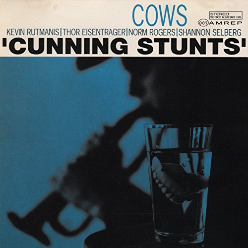 CD cover for āCunning Stuntsā by Cows, featuring a saxophone and teeth in water.