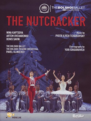 Ballet dancers in red and white costumes on stage with a Christmas tree behind.