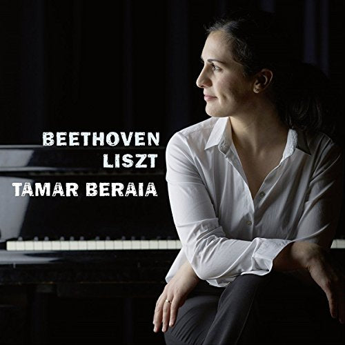 Woman in white shirt sits beside a piano with composers' names displayed.