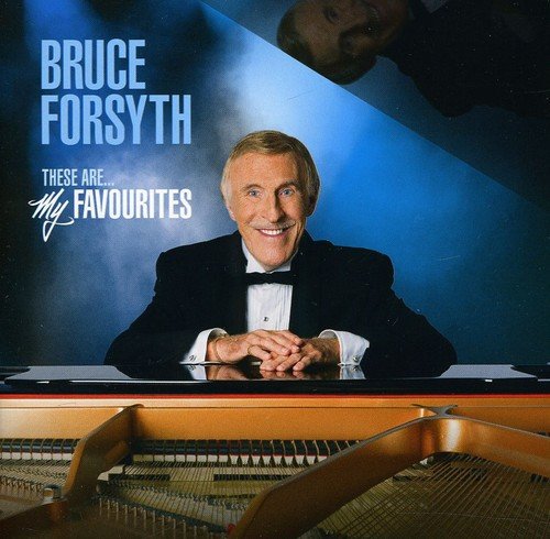 Bruce Forsyth in a tuxedo behind a piano on a blue background.