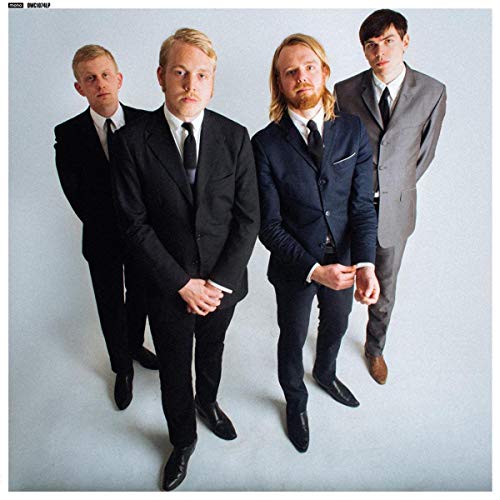 Four men in dark suits pose against a pale gray background.