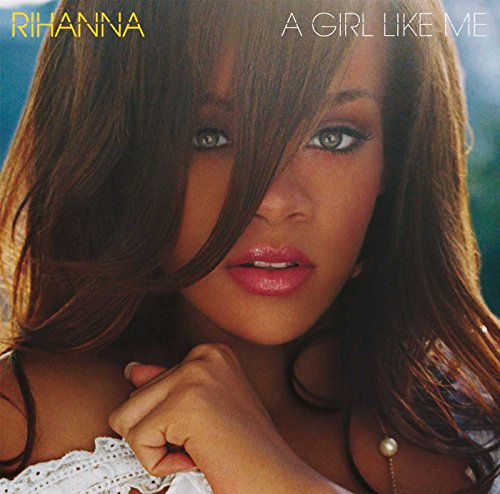 Close-up portrait of Rihanna with long brown hair and a white top.