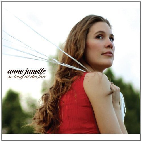 "Album cover featuring a woman in a red sleeveless top, with white ribbons near her face."