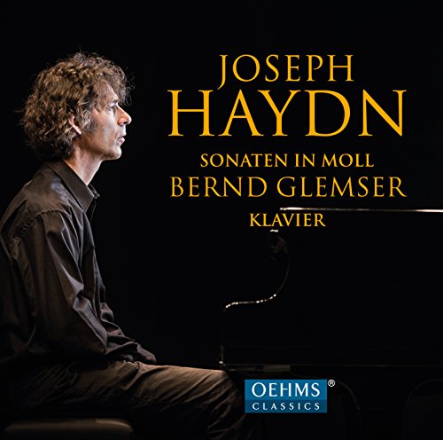 "CD cover featuring a man sitting at a piano against a black background."