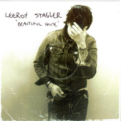 Album cover with man in denim jacket, hand on face, sepia tone.