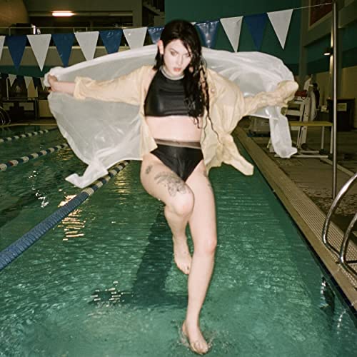 Woman in swimwear poses dramatically at the edge of a pool.