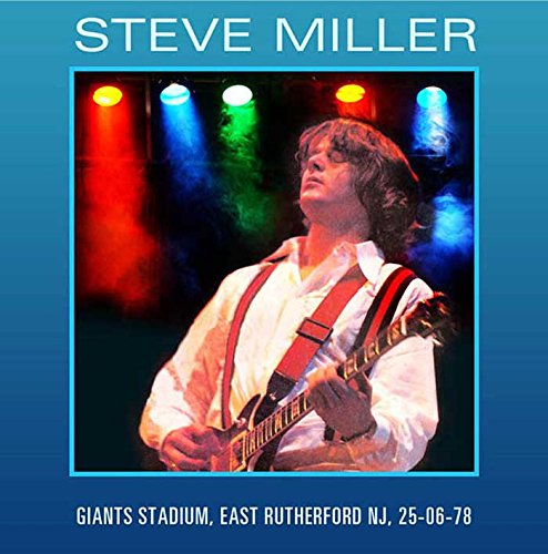 Steve Miller playing guitar onstage with colorful stage lighting.