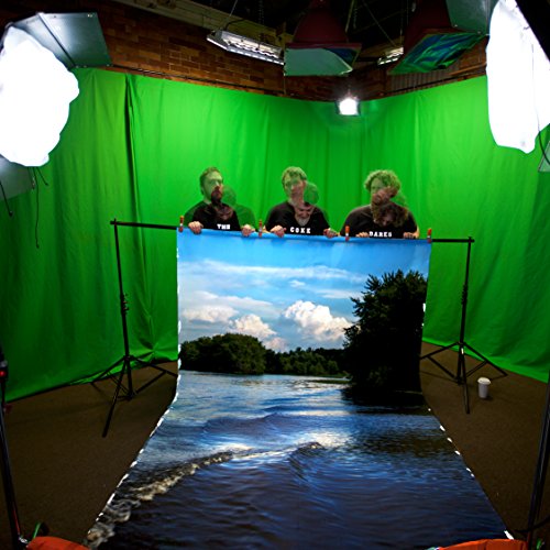 Three people holding a lakeside image in front of a green screen.