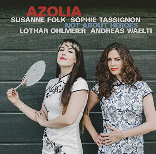CD cover with two women in patterned dresses against a green wall.