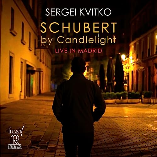 CD cover: Back view of man on a dimly lit Madrid street.
